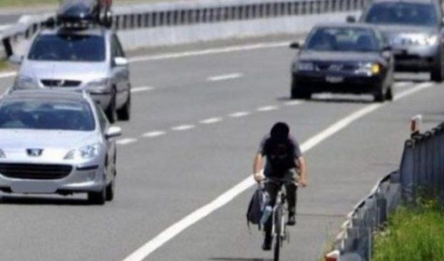 Uomo in biclicletta sull'autostrada