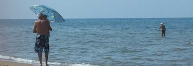 IL NONNO CON OMBRELLONE E NIPOTINO IN BRACCIO CHE COMMUOVE:"LA FOTO PIU' BELLA DELL'ESTATE"